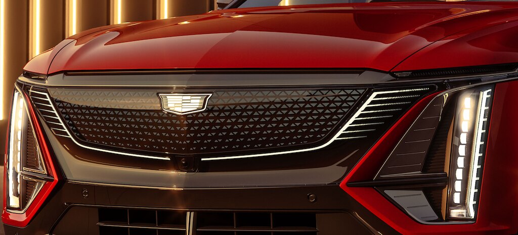 Lujosa parrilla con iluminación LED y emblema de cristal negro dramáticamente iluminada en Cadillac Lyriq, camioneta eléctrica